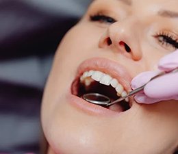 Close up of woman’s mouth and dental mirror