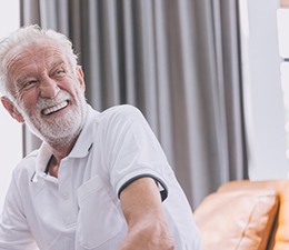 a man with dentures smiling while at home