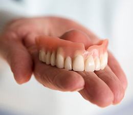 a person holding a brand-new dentures
