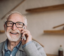 Man with black framed glasses chatting on his smartphone