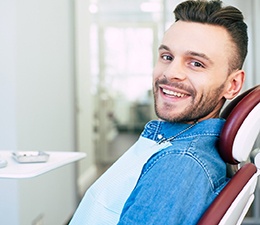 A young man smiling while sitting in a dental chair